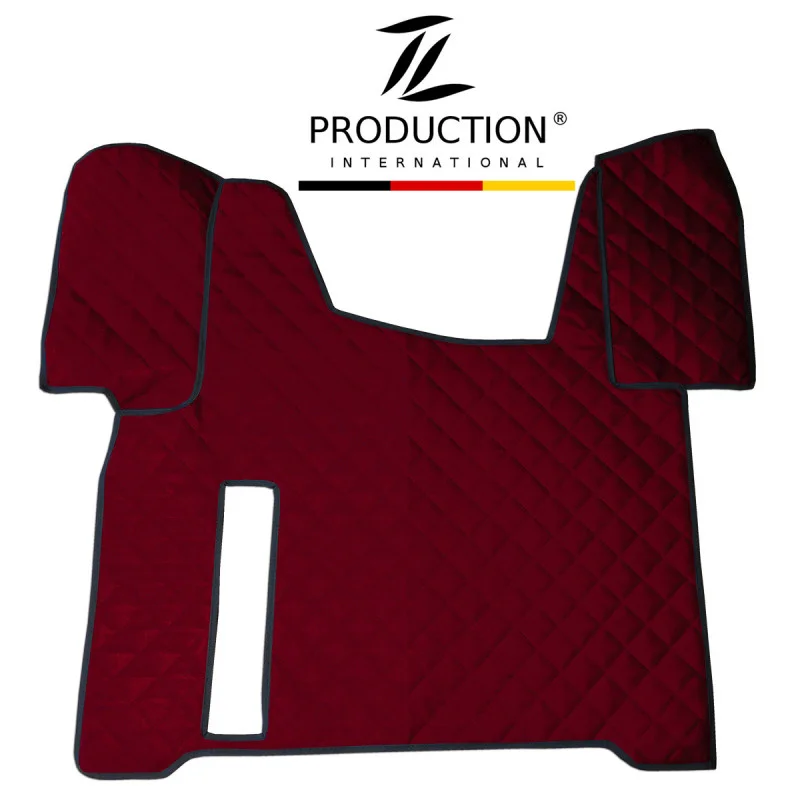 Auf weißem Hintergrund ist eine dunkelrote, gesteppte Kunstleder-Tunnelabdeckung mit schwarzen Kanten zu sehen. Sie wurde für den MAN TGS entworfen und weist eine symmetrische Form mit Abschnitten für die Armaturenbrett- und Lenkradseiten auf und außerdem einen Ausschnitt für die Handbremse. Darüber das Logo „TL Production International“.