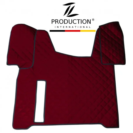 Auf weißem Hintergrund ist eine dunkelrote, gesteppte Kunstleder-Tunnelabdeckung mit schwarzen Kanten zu sehen. Sie wurde für den MAN TGS entworfen und weist eine symmetrische Form mit Abschnitten für die Armaturenbrett- und Lenkradseiten auf und außerdem einen Ausschnitt für die Handbremse. Darüber das Logo „TL Production International“.