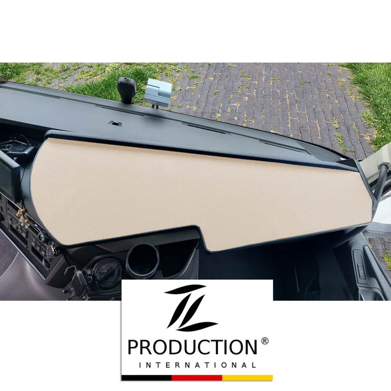Das LKW-Tisch für den Volvo FH ist elegant mit einer beigefarbenen Antirutschmatte bedeckt. Der Blick umfasst Teile der Windschutzscheibe und des Seitenspiegels. Ein Logo am unteren Rand zeigt „TL Production International“, während die Matte einen starken Kontrast zum dunklen Innenraum bildet.